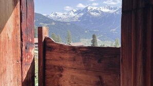Eine Holzhütte mit Blick auf schneebedeckte Berge.