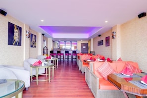 A hotel lobby with seating areas, a bar, and artwork on the walls. - The Fern Denzong Hotel And Spa, Gantok (Gangtok)