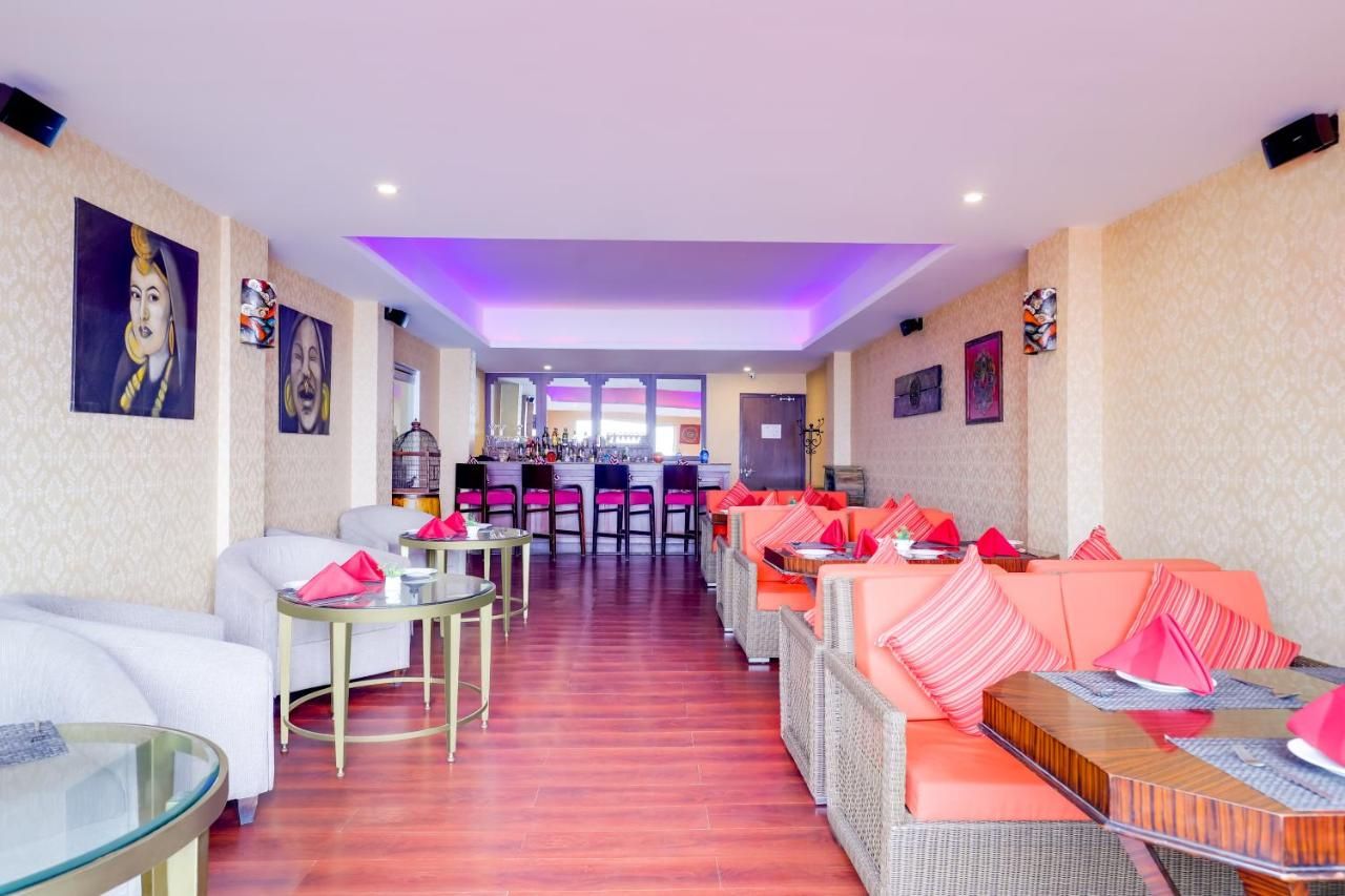 Um hall de hotel com áreas de estar, um bar e obras de arte nas paredes.