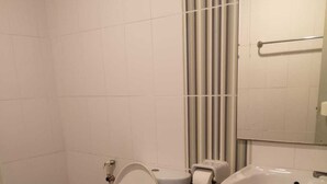 Un baño con inodoro, lavabo y espejo.