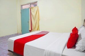 Una stanza con un letto, una finestra con tenda e una porta.
