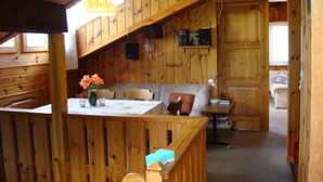 A wooden cabin interior with a dining area, a sofa, and a staircase. - Haus Vernier, (Seewis). by Interhome (Seewis im Prättigau)