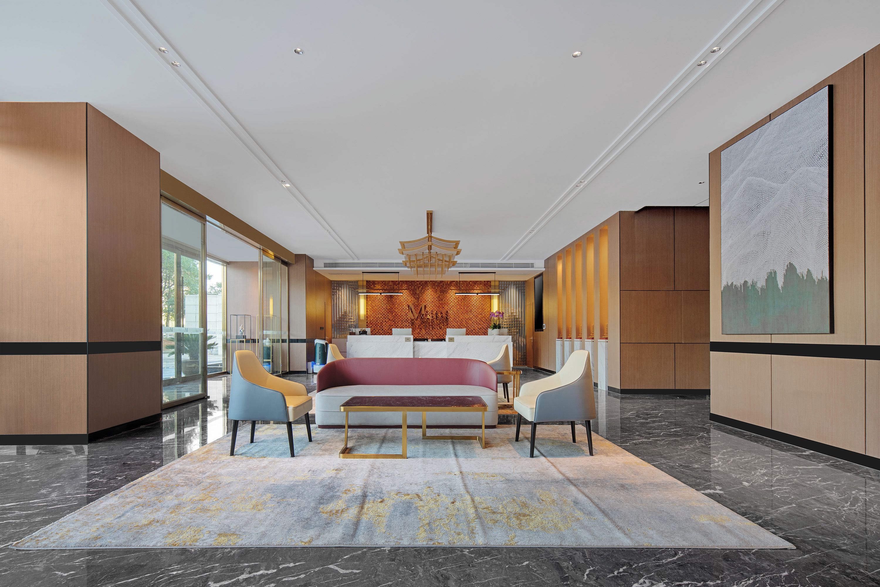 Un moderno vestíbulo de hotel con una cama grande, zona de estar y un mostrador de recepción.