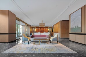 Un hall d’hôtel moderne avec un grand lit, un coin salon et un comptoir d’accueil.