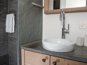 Une salle de bain avec un lavabo blanc, un miroir et une serviette suspendue à un porte-serviettes.