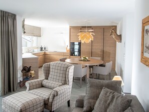Un salon moderne comprenant un canapé, un fauteuil et une table à manger avec des chaises.
