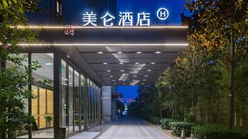 L'ingresso di un hotel dal design moderno, con porte in vetro e un vialetto ben illuminato.