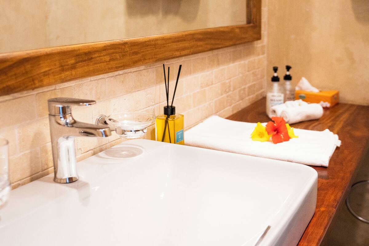 Un bany amb un lavabo gran, un mirall i una barra de tovalloles.