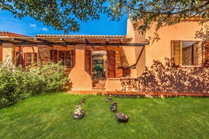 A house with a patio, a covered entrance, and a well-maintained lawn with decorative rocks. - Lu Maggiu, Santa Teresa di Gallura, Italy (Santa Teresa di Gallura)