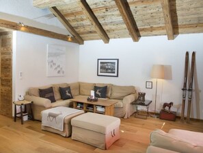 A cozy living room with a wooden ceiling, a sofa set, a small table, and a lamp. - Zentrale 3.5 Zimmer Wohnung Seegarten B- Lenzerheide by Interhome (Lenzerheide)