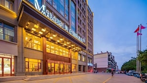 A hotel with a modern facade, large glass windows, and a prominent entrance.