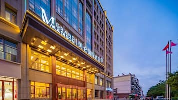 A hotel with a modern facade, large glass windows, and a prominent entrance.