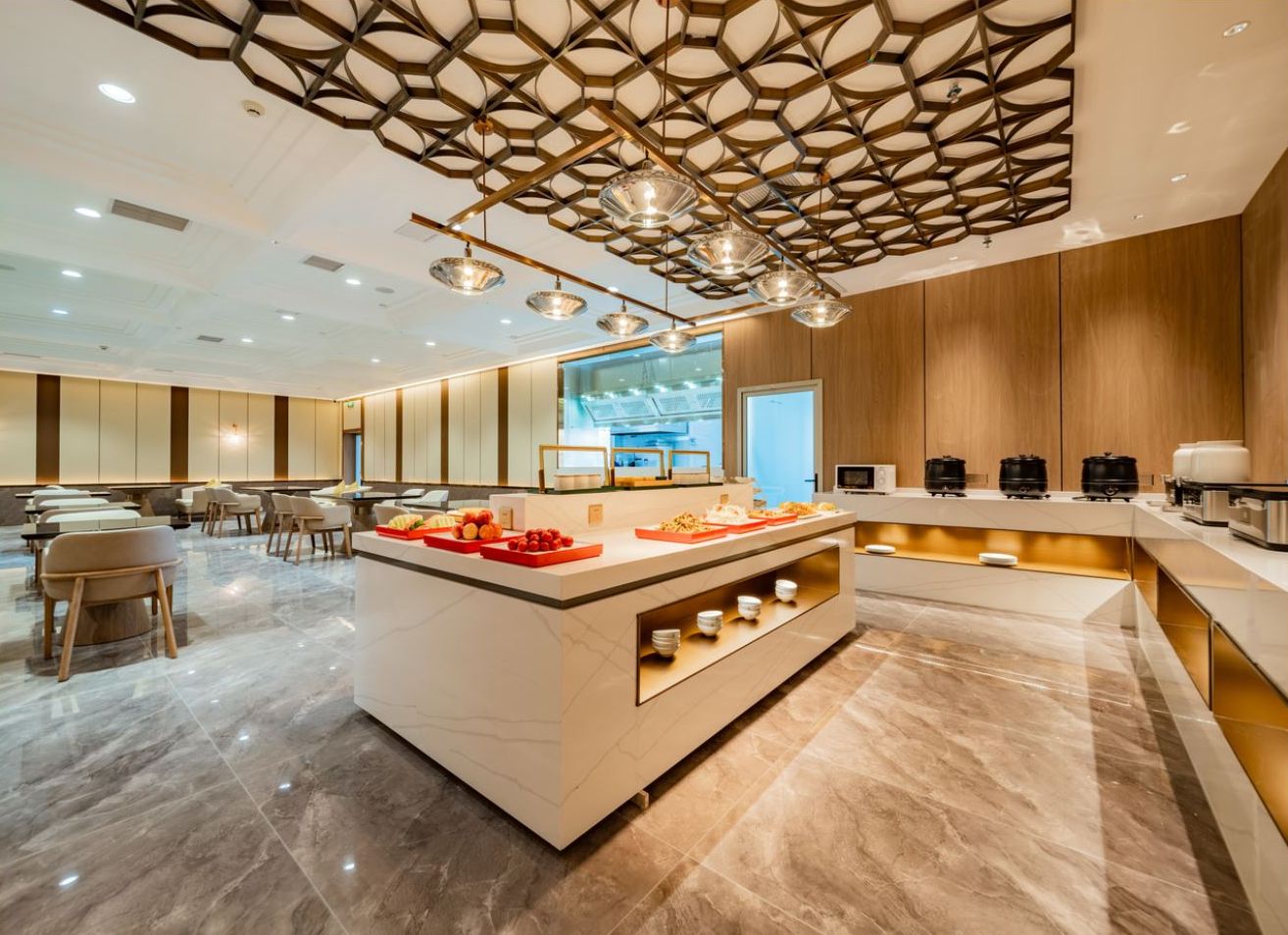 A modern hotel lobby with a central island, seating area, and a kitchen counter.