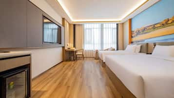 A hotel room with a bed, a desk, a television, and a window with a view.