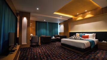 Ein Hotelzimmer mit Bett, Schreibtisch, Stuhl und Fernseher.