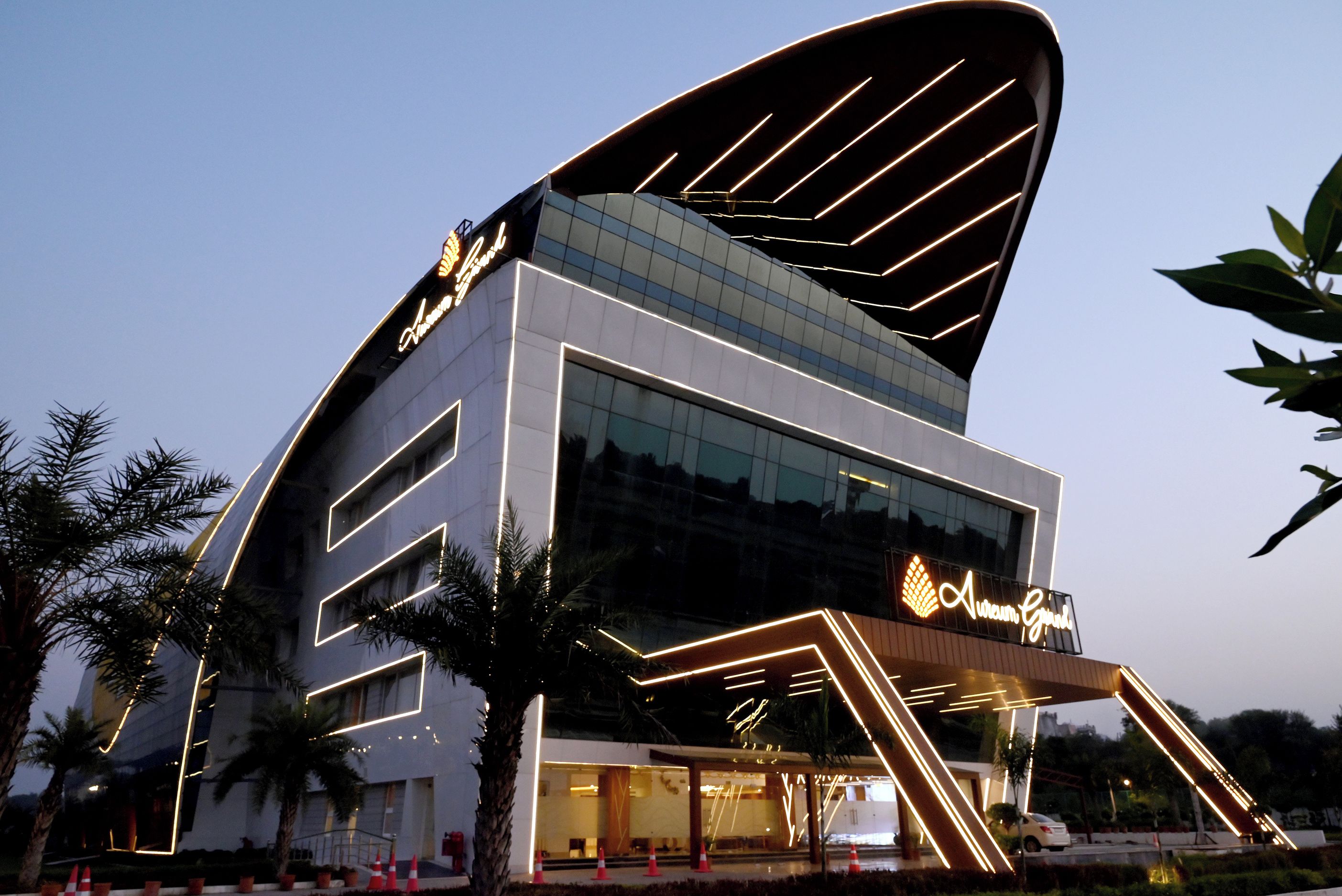 A modern building with a distinctive curved roof and illuminated signage.