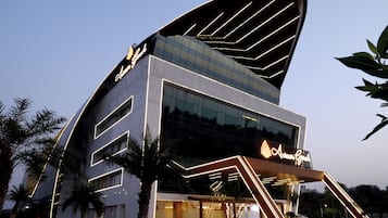 A modern building with a distinctive curved roof and illuminated signage.