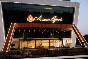 Un edificio moderno con un letrero llamativo que dice 'Aureum Grand'.