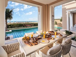 Comedor con vista a la piscina, mobiliario exterior y mesas para buffet.