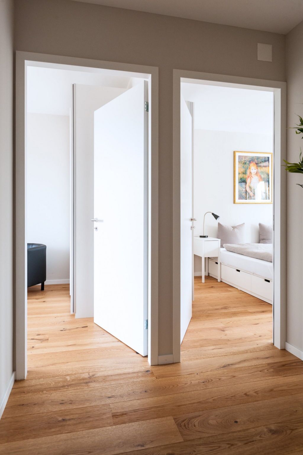Un interior moderno con suelo de madera, paredes blancas y sofá blanco.