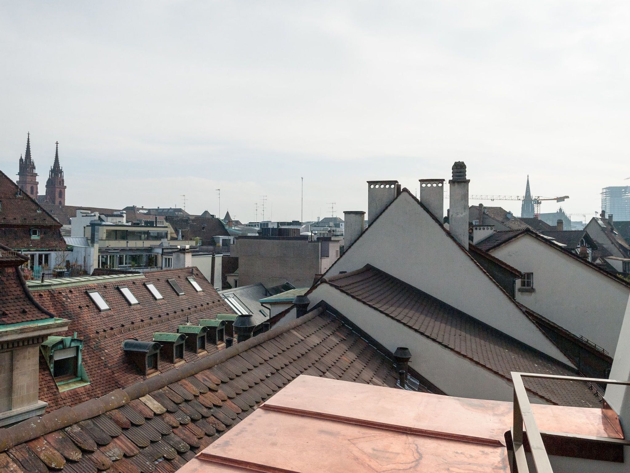 Paisatge urbà que combina arquitectura històrica i moderna, incloent una església destacada amb dues torres geminades i una varietat d'estils arquitectònics.