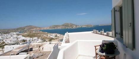 A balcony with a view of the sea and white buildings.