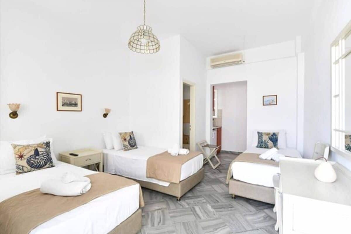 A hotel room with two beds, a desk, and a chair.