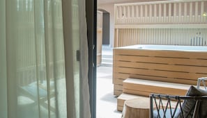 A modern interior with a wooden bench, a small round table, and a view through a glass door. - Senseana Seaside Resort And Aquadventure (Analipsis)