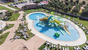 An aerial view of a water park with a large pool, slides, and sun loungers. - Senseana Seaside Resort And Aquadventure (Analipsis)