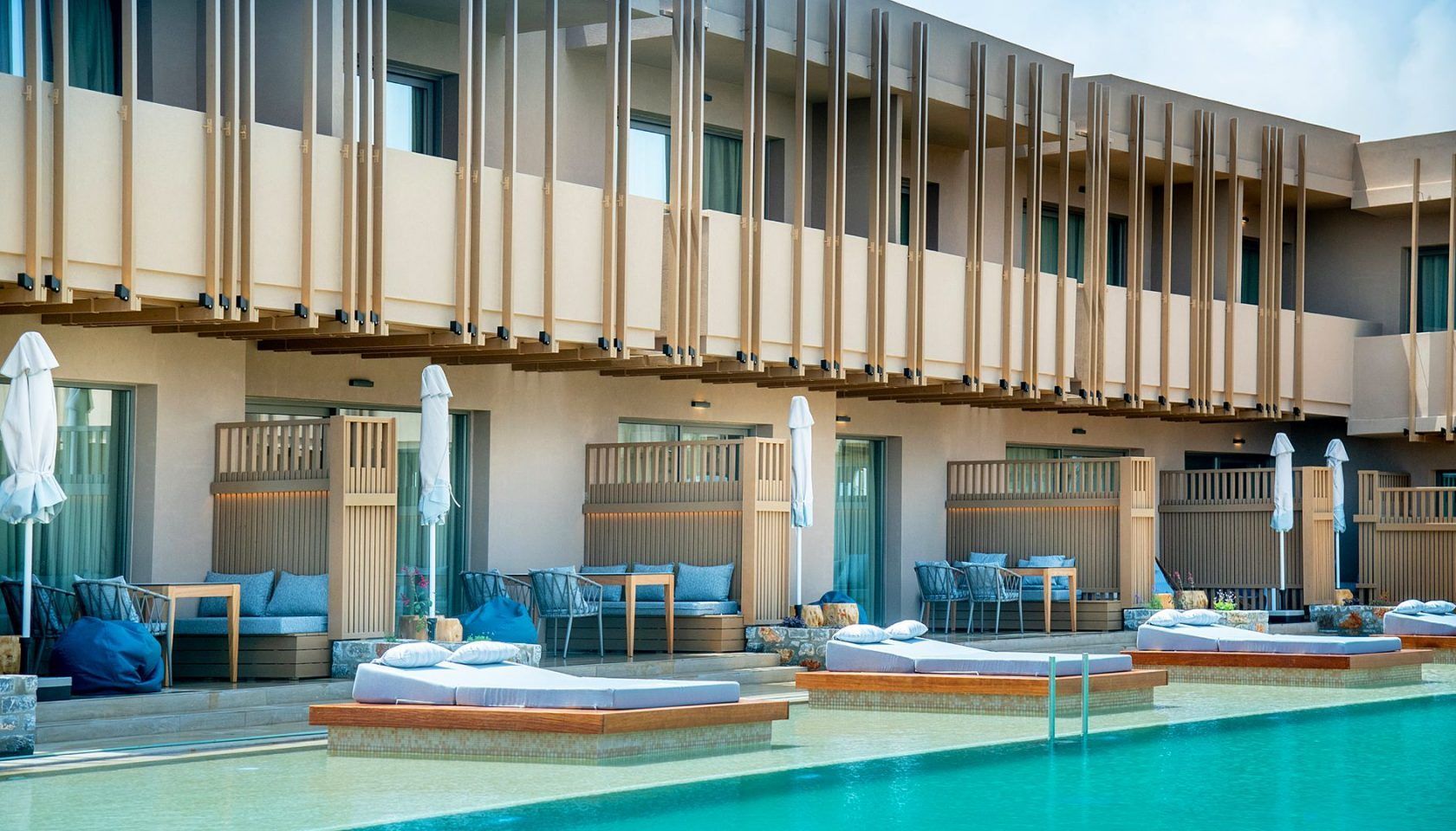 A hotel pool area with lounge chairs, umbrellas, and a clear view of the pool.