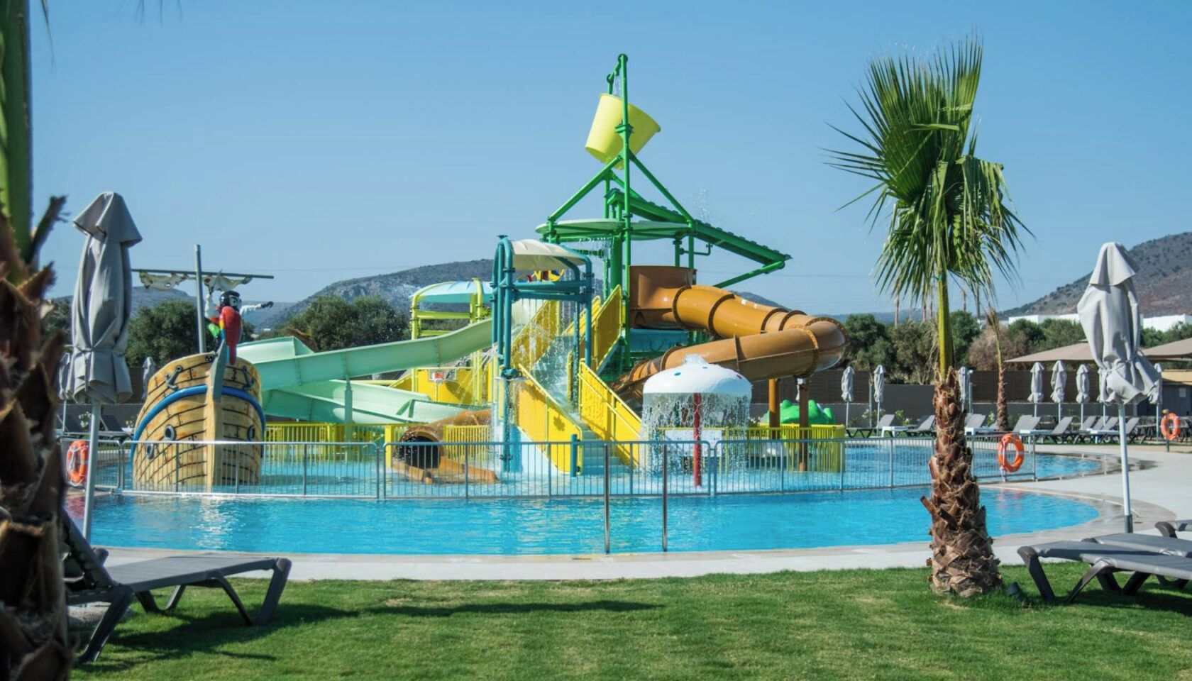 Egy vízi park, amelyben nagy medence, csúszdák és egy játszóterület található.