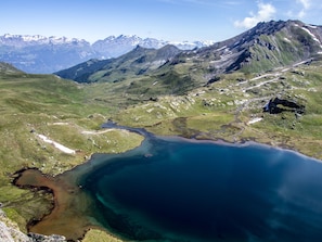 A mountainous landscape with a large lake and a winding path. - Chalet Albarose - Vercorin by Interhome (Vercorin)