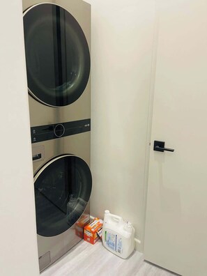 Ein Waschraum mit zwei Waschmaschinen und einer Flasche Waschmittel.