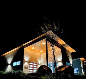 Un bĂątiment moderne dotĂ© dâune façade en verre, dâun toit en bois et dâune porte bien visible.