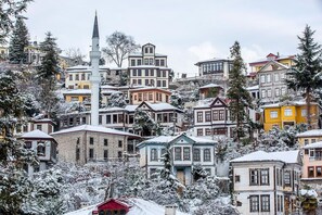 Eine verschneite Stadt mit historischen Gebäuden, darunter ein markanter weißer Turm.