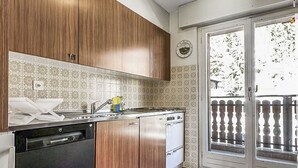 Una cocina con armarios de madera, lavavajillas y estufa.