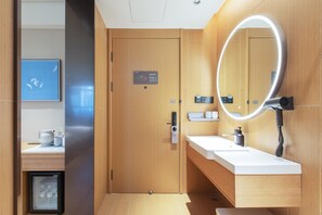 Ein modernes Badezimmer mit einem Holzkosmetikschrank, einem Spiegel und einer Toilette.