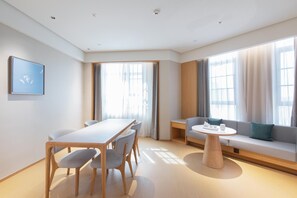 Ein modernes Zimmer mit Esstisch, Stühlen, einer Couch und einem kleinen Couchtisch.