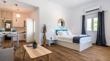 Quarto moderno com cama, mesinha, cadeira, espelho e janela com cortinas.