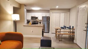 Een compacte leefruimte met een kitchenette, een eetgedeelte en een zithoek.