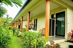 A hotel with a covered outdoor area, wooden pillars, a bench, and a bicycle rack. - Seatiki Fiji (Sigatoka)