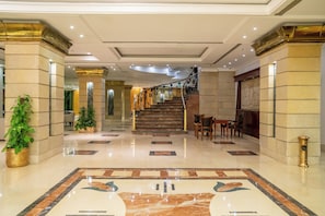 A spacious lobby with a marble floor, a staircase, and a reception desk. - Azal Pyramids Hotel (Kafr ad-Dawwar)