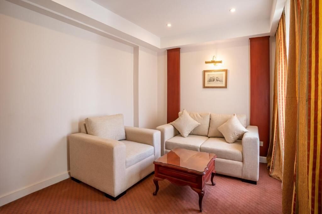 A room with two sofas, a wooden coffee table, and a framed picture on the wall.