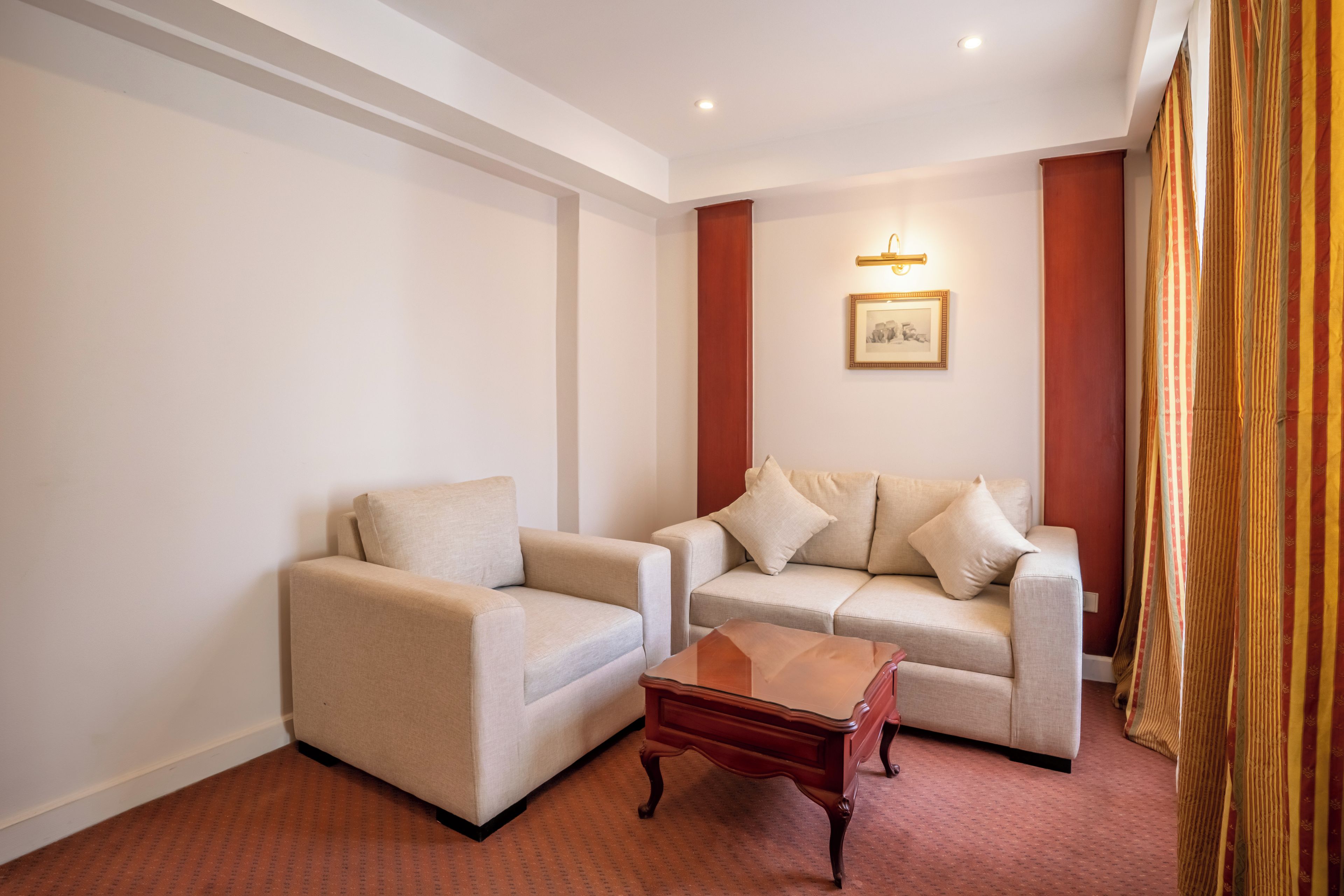 Ein Zimmer mit zwei Sofas, einem Holztisch und einem gerahmten Bild an der Wand.