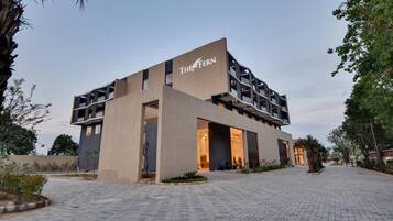 A modern building with a flat roof, a sign reading 'THE FERN,' and a paved entrance area.