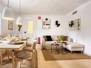 Een moderne woonkamer met een eethoek, een bank, een salontafel en een open haard.