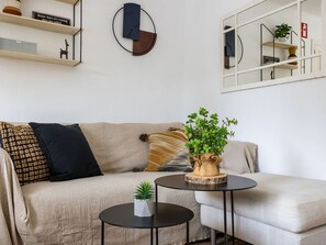 A living room with a sofa, a coffee table, a mirror, and a shelf with decorative items. - La Casa Escaniana by Interhome (Santanyí)
