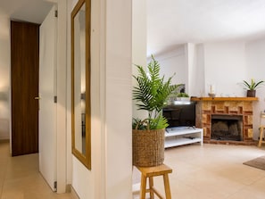A modern living room with a fireplace, a television, and a wooden door. - La Casa Escaniana by Interhome (Santanyí)