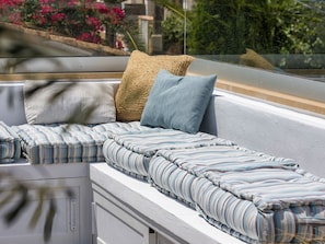A balcony with a seating area featuring striped cushions and a woven pillow. - La Casa Escaniana by Interhome (Santanyí)