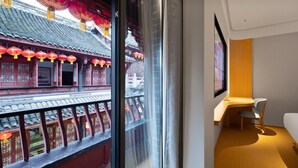 A room with a traditional Chinese architectural view through a window, a modern desk, and a chair. - Ji Hotel Chongqing Bishan Cbd Xiuhu Park (Chongqing)